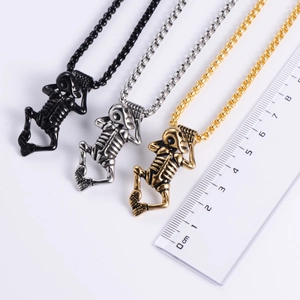 Close-up of gothic skull skeleton pendants in black, silver, and gold steel with rulers