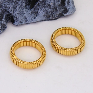 Detailed view of two gold-plated Tubogas rings with flexible ribbed texture and polished finish