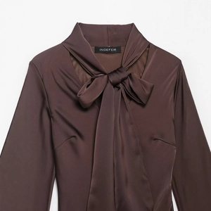 Vestito a maniche lunghe in raso marrone con elegante fiocco su sfondo bianco