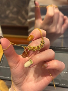 Gros plan du bracelet de pièces dorées avec breloque porte-bonheur sur un poignet