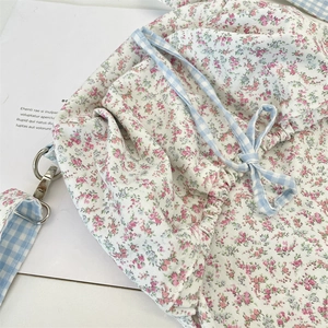 Detail of floral canvas bag featuring pink flower patterns and blue checkered straps