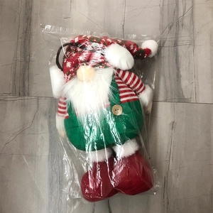 Detailed view of Christmas gnome plush doll featuring a red knitted hat and green overalls