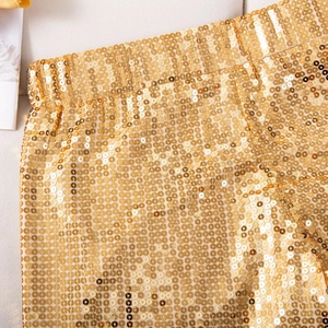 Makroaufnahme goldener Pailletten und elastischem Bund an High-Waist-Partyshorts