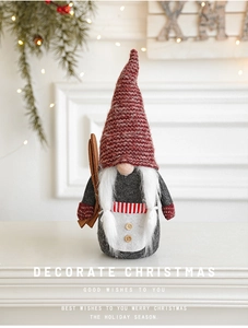 Detailed close-up of a Christmas gnome doll with a red knit hat and wooden sledge decoration