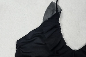Detail of elegant black dress showing ruffled mesh shoulder straps and tulle fabric texture