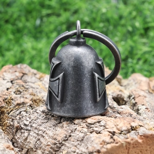 Detailed macro of vintage stainless steel biker bell with embossed cross on rustic wood