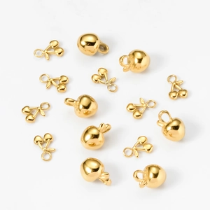 Macro detail of 18k gold plated stainless steel cherry and apple charms for jewelry DIY