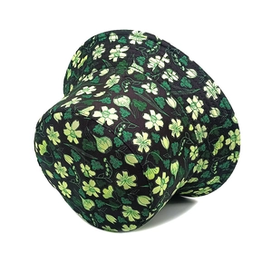 Close-up of black floral bucket hat with green botanical print and detailed stitching