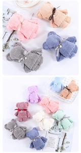 Detail of coral fleece towels folded into teddy bears with pearls and bows for gifts