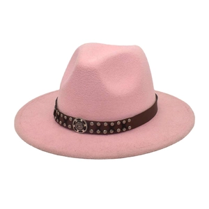 Close-up of pink wool fedora with brown leather band, silver studs and vintage metal badge