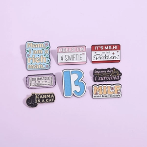 Enamel pin set with Taylor Swift lyrics and Eras Tour motifs on a purple background