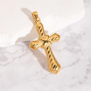 Pendentif croix en acier inoxydable doré texturé sur fond marbre, finition de qualité