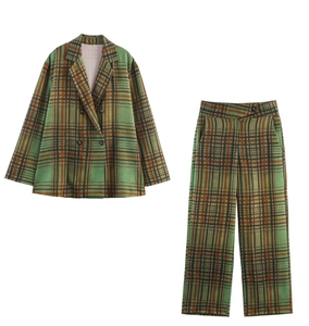 Dettaglio di un completo scozzese verde con blazer doppiopetto e pantaloni a zampa