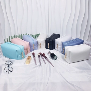 Multiple colors of cross-texture PU leather makeup bags with gold zippers and brushes