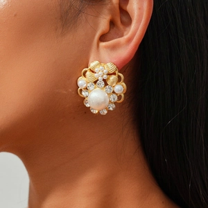 Close-up of vintage flower earrings with pearls and crystals on a female model