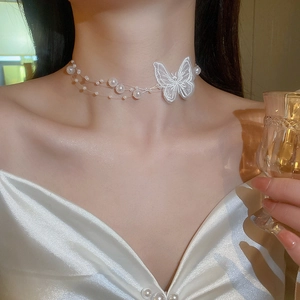 Collier élégant avec papillon en organza blanc et perles porté par un mannequin