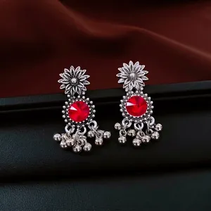 Bohemian retro floral earrings with red gems and silver tassel bells on silk display