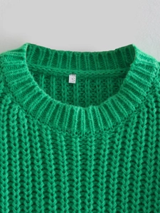 Dettaglio di un maglione in maglia verde acceso con girocollo ed etichetta della taglia S