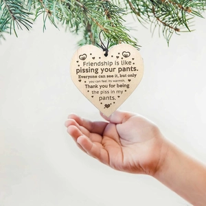 Funny friendship wooden heart ornament hanging on a pine branch with humorous English quote