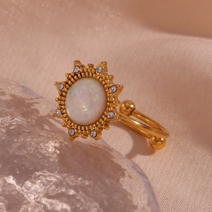Macro shot of 18K gold plated opal ring with starburst cz halo on soft silk fabric