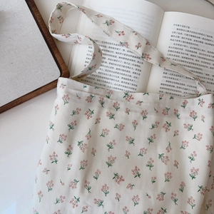 Detail of floral cotton handbag fabric with vintage floral print on cream canvas
