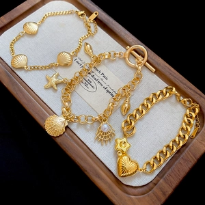 Detailed view of gold ocean charms featuring starfish, shell and heart on various chains
