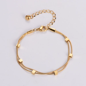 Detail of gold double-layer snake chain bracelet with cube charms and lobster clasp