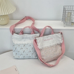 Detailed lace trim and floral embroidery on a large capacity canvas crossbody bag