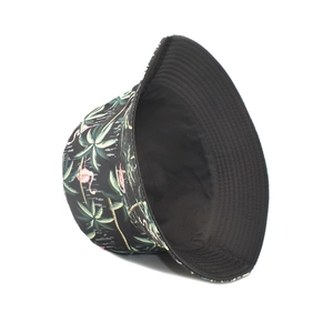Detail of reversible bucket hat featuring tropical floral print and black canvas lining