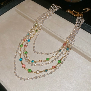 Détail d'un collier de perles multicouche avec pierres précieuses et fermoir doré
