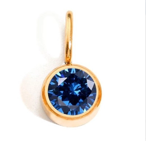 Macro view of gold-plated stainless steel pendant with round dark blue gemstone