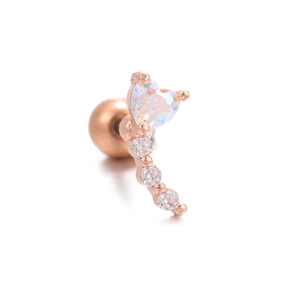 Gros plan sur clou d'oreille en or rose avec opale en cœur et petits zircons brillants