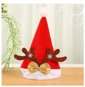 Détail d'un bonnet de Noël rouge avec des bois de renne bruns et un nœud doré décoratif