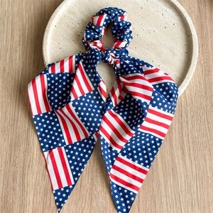Detail of USA flag pattern hair scrunchie with long ribbons on a minimalist stone tray