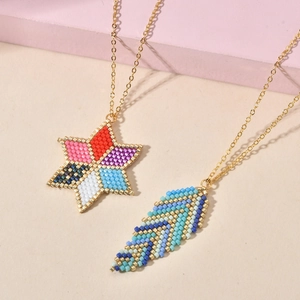 Detail of colorful beaded bohemian necklaces with gold star and feather pendants