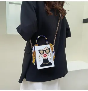 Detail of box clutch bag with pop art portrait, silk scarf handle and gold chain strap