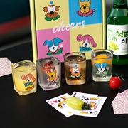 Detail view of shot glasses with dog illustrations and matching gift box on a table