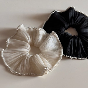Close-up of cream and black mercerized yarn hair scrunchies with delicate pearl trim
