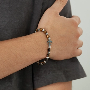 Men's tiger eye beaded bracelet with stainless steel anchor charm on wrist