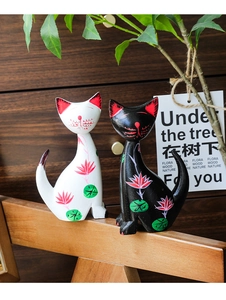 Detailed view of hand-painted floral patterns on pair of cat animal art figurines