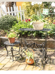 Außenansicht von schwarzen Eisen-Blumenständern mit aufwendigem Hohl-Rollwerk-Muster