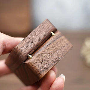 Macro shot of premium black walnut wood grain and golden metal hinge on jewelry box