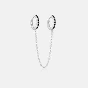 Detail of S925 silver double hoop earrings with black zircon stones and a delicate chain link