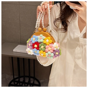 Close-up of pink handmade crochet bag with colorful floral embroidery and pearl strap