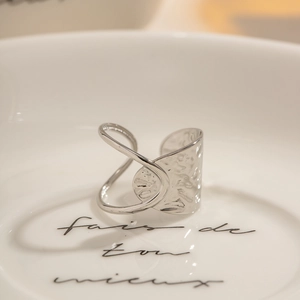 Minimalist hammer textured silver stainless steel open ring on a white ceramic tray