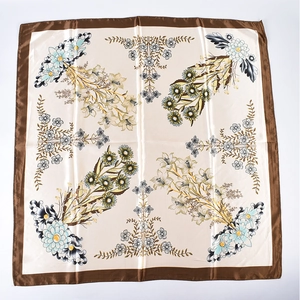 Detailed view of floral satin square scarf featuring brown borders and silky texture