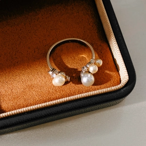 Detail of an open gold ring with four pearls and cubic zirconia in a velvet box