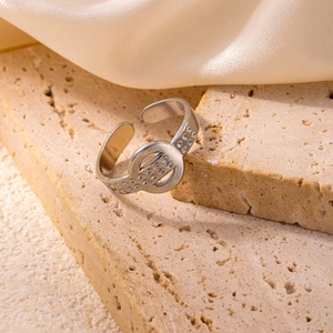 Detail of silver stainless steel adjustable ring with dot texture on travertine stone