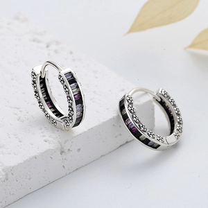 Detailed close-up of S925 silver rainbow hoop earrings with purple stones on white stone