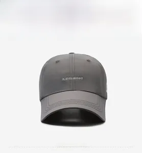 Détail de casquette grise avec broderie et surpiqûres renforcées sur la visière